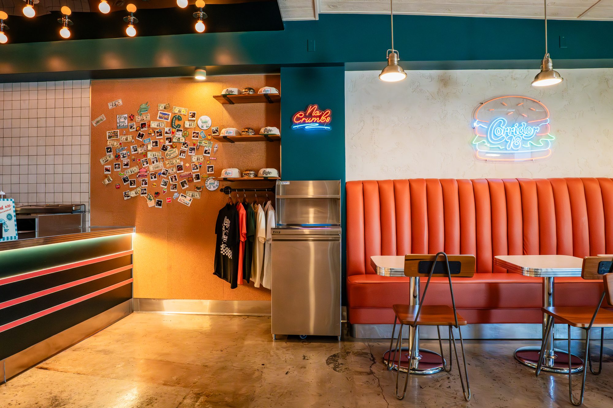 Corridor 18 burger club interior with orange banquettes, teal walls and neon signage